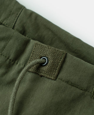 Olive trouser pocket with fabric tab and metal grommet; button closure