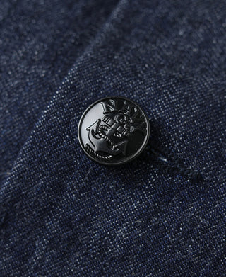 Indigo denim jacket button with embossed nautical-style emblem