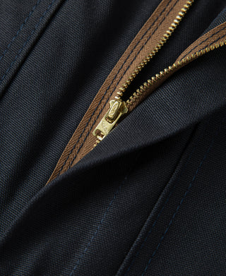 Navy zipper pocket close-up with tan zipper track and reinforced seam stitching