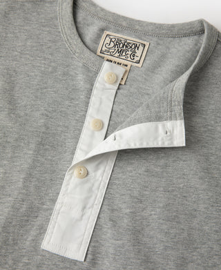 Gray henley T-shirt neckline close-up with white placket and three button closures