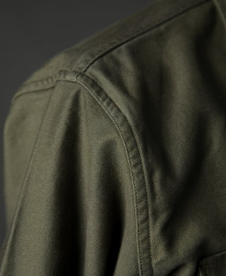 Olive shirt shoulder and sleeve seam detail with stitched yoke panel