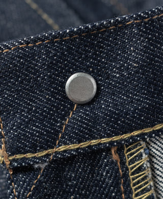 Dark blue selvedge denim with round metal button and contrast tan stitching