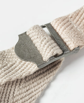 Natural linen tote bag strap attachment with metal rivet and woven webbing.