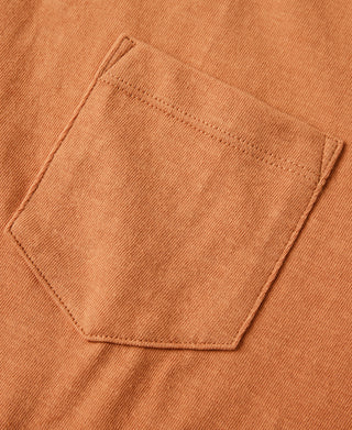 Orange chest pocket on a slub cotton t-shirt with stitched pocket outline.