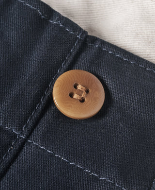 Navy trouser button detail with tan button and stitched buttonhole