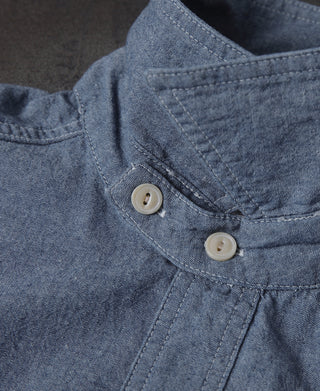 Blue chambray shirt placket detail with two beige buttons and stitching