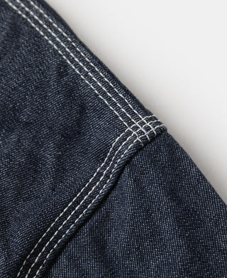 Indigo denim jacket seam with dense diagonal topstitching at the shoulder