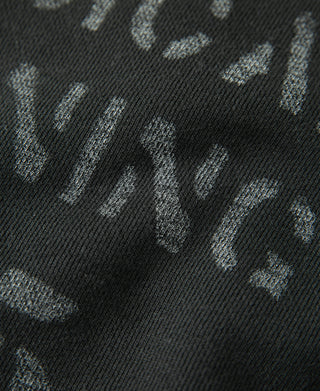 Vintage black sweater fabric close-up with worn “Physical Training” text detail