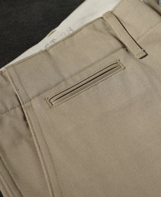 Tan chino trousers showing front pocket flap detail and straight seams