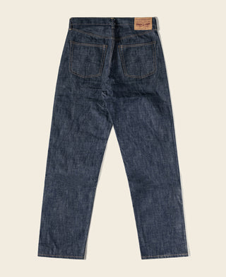 Dark blue straight denim jeans, front view with leather brand patch