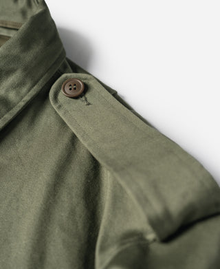 Olive field jacket sleeve with brown button and stitched seam at cuff