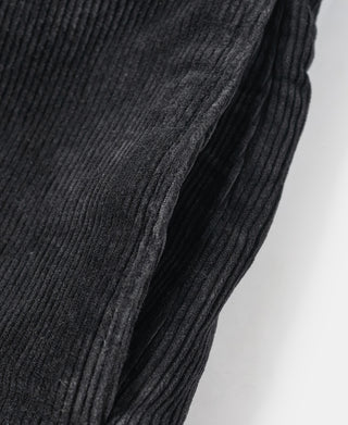 Black corduroy pants leg with ribbed texture and side seam stitching.