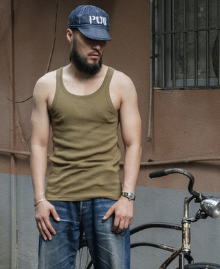 Olive cotton tank top on model, crew neckline and sleeveless shoulders