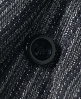 Dark button on striped pants fabric