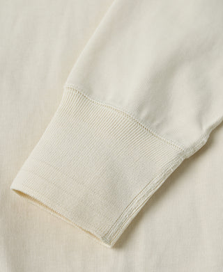 Ribbed long-sleeve cuff detail on a light cream henley shirt