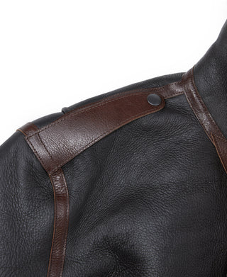 Dark leather flight jacket with brown shoulder strap and top button