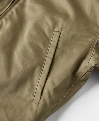 Olive bomber jacket sleeve with vertical zip pocket and contrast stitching detail.