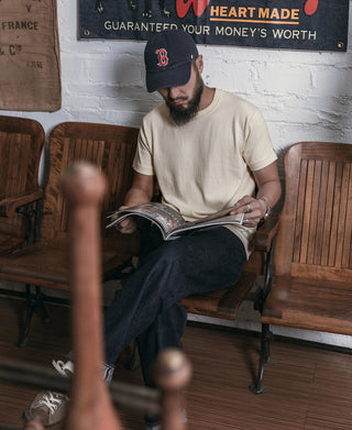 Apricot athletic T-shirt with crew neck and short sleeves, model seated.