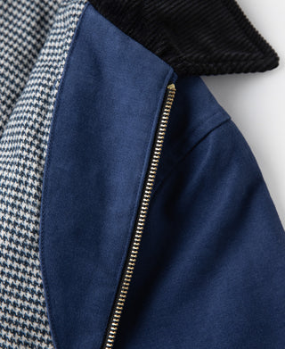 Blue jacket front with gold zipper and black corduroy-style collar