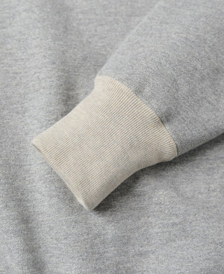Gray sleeve cuff rolled seam with off-white ribbed cuff band detail.
