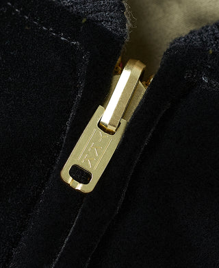 Gold metal zipper pull on black jacket with plush texture