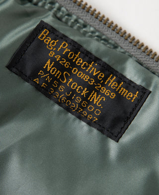 Sage green helmet bag label with printed care info on interior panel