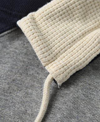 Hooded sweatshirt cuff close-up, cream ribbed trim with gray sleeve and drawstring