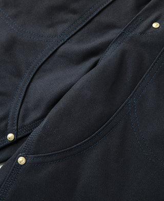 Navy canvas front pocket with curved pocket opening and brass button rivet