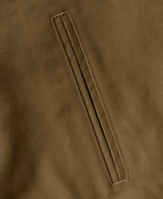 Brown bomber jacket vertical welt pocket with reinforced edge stitching.