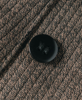 Brown salt-and-pepper striped pants fabric close-up with dark button detail