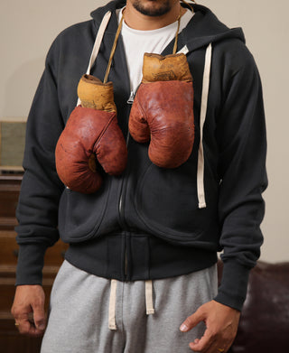 Black zip-up hoodie with drawstring hood, kangaroo pocket, and ribbed trim