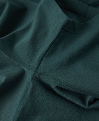 Dark green t-shirt neckline and shoulder seam with smooth fabric folds