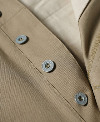Tan chino trousers with three metal button closures at waistband