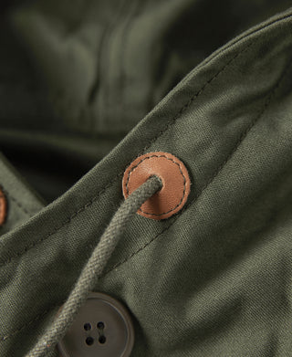 Olive parka sleeve cuff detail with tan leather button patch and stitched fabric