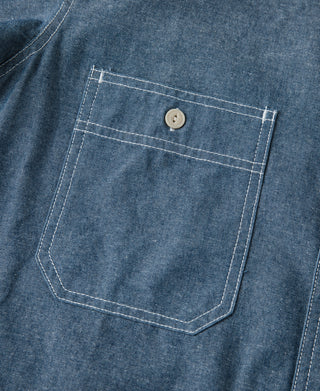 Blue chambray chest pocket with stitched outline and beige button