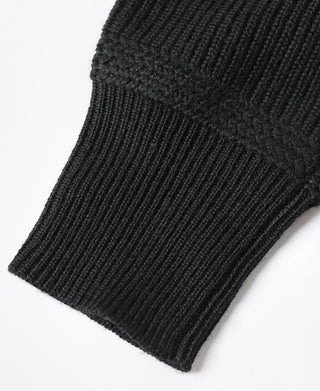 Black ribbed knit sweater cuff close-up at sleeve end