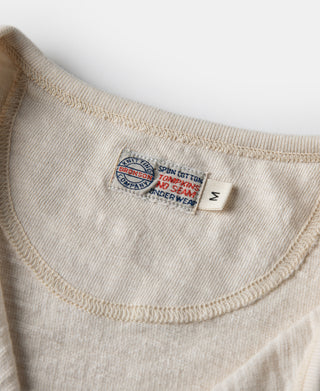 Loopwheel henley t-shirt neck label with size tag on apricot-beige fabric