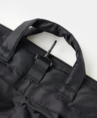 Black nylon helmet bag close-up of webbed strap and zipper pull