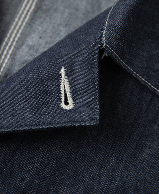Indigo denim jacket bar-tack stitch detail near the pocket corner