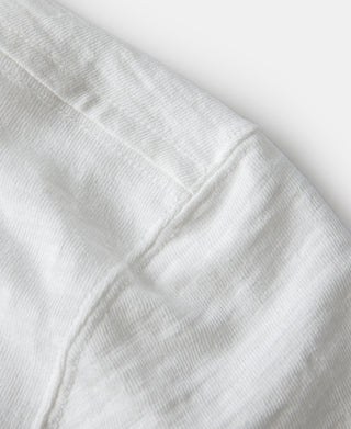 Close-up of white cotton t-shirt fabric seam and stitching detail
