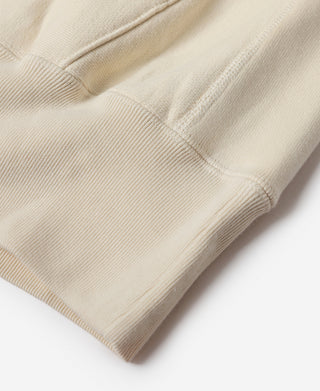 Apricot hoodie ribbed hem and pocket area close-up.
