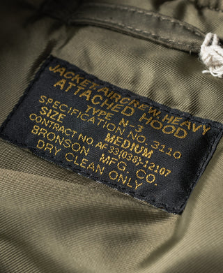 Olive N-3 parka inside label with care and manufacturer text stitched on.