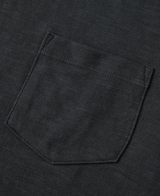Black T-shirt chest pocket detail with visible double-stitched edges