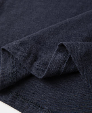 Navy t-shirt fabric close-up with stitched seam and soft knit texture
