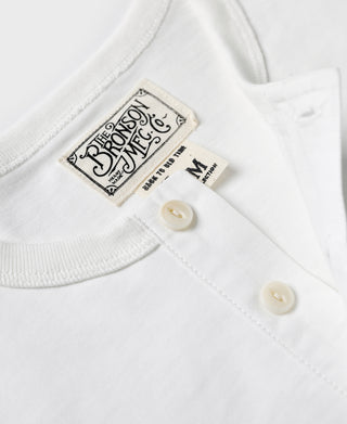 White henley t-shirt neckline with brand label and cream button placket