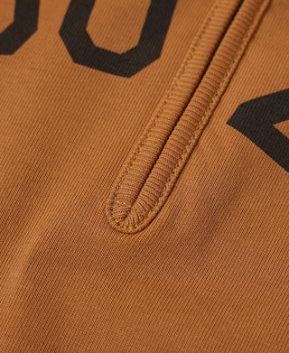 Close-up of orange quarter-zip seam and front graphic on long-sleeve T-shirt