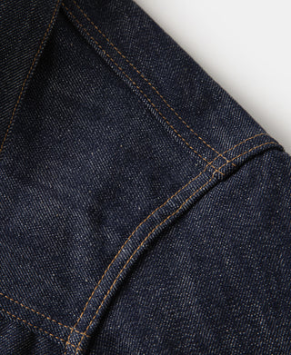 Indigo denim jacket panel with orange topstitching and seam detail