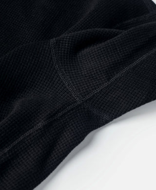 Black waffle-knit sleeve cuff and seam detail close-up