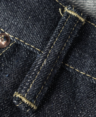 Indigo denim pocket area close-up with gold contrast stitching