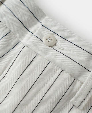 White pinstripe pants close-up: buttoned waistband and belt loop tabs